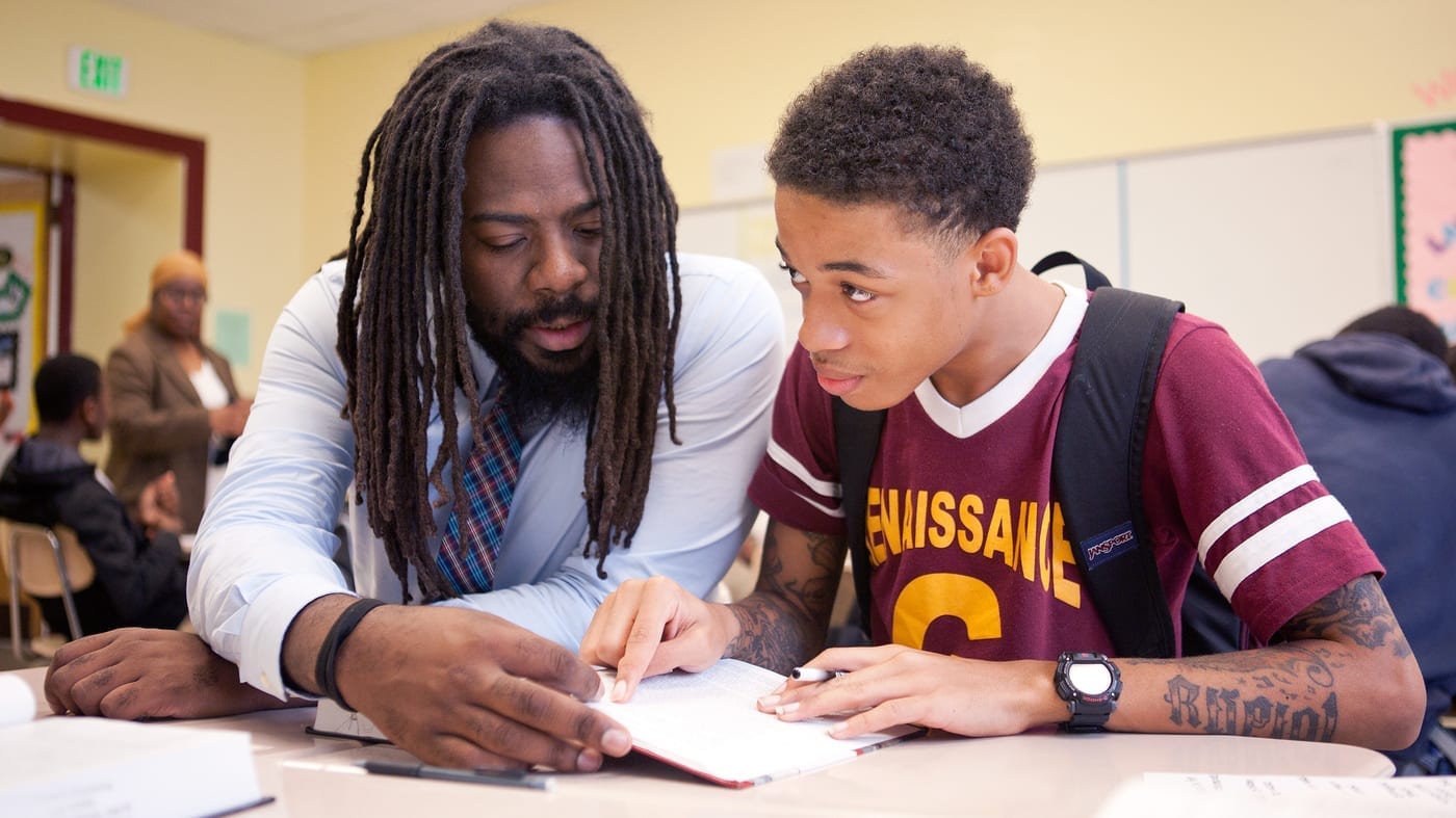 Mentor encouraging a young man outside a community center